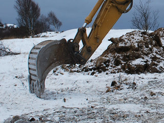 Gravemaskin på tomt Gravemaskin på tomt