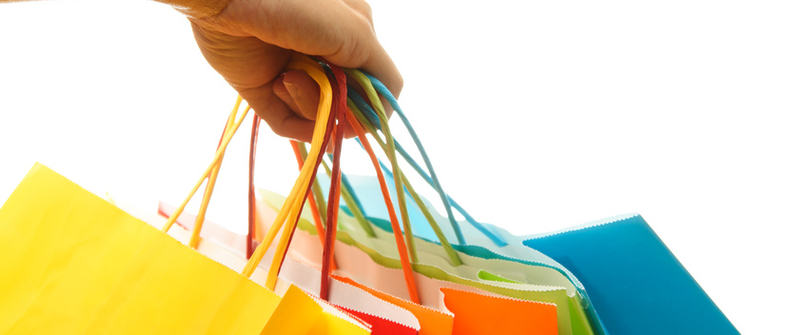 A woman hand carrying a bunch of colorful shopping bags A woman hand carrying a bunch of colorful shopping bags