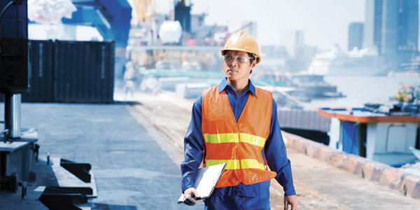 Man walking on shipyard with notes