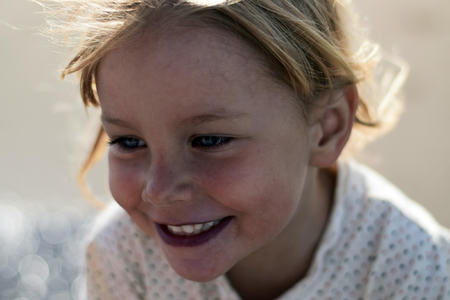 Nærbilde av ansiktet til en glad jente på rundt fire år