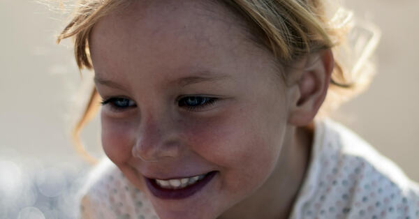 Nærbilde av ansiktet til en glad jente på rundt fire år