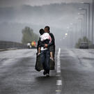 Idomeni, Greece 2015 © Yannis Behrakis / Reuters A Syrian refugee kisses his daughter as he walks through a rainstorm towards Greece’s border with North Macedonia, near the Greek village of Idomeni, September 10, 2015.