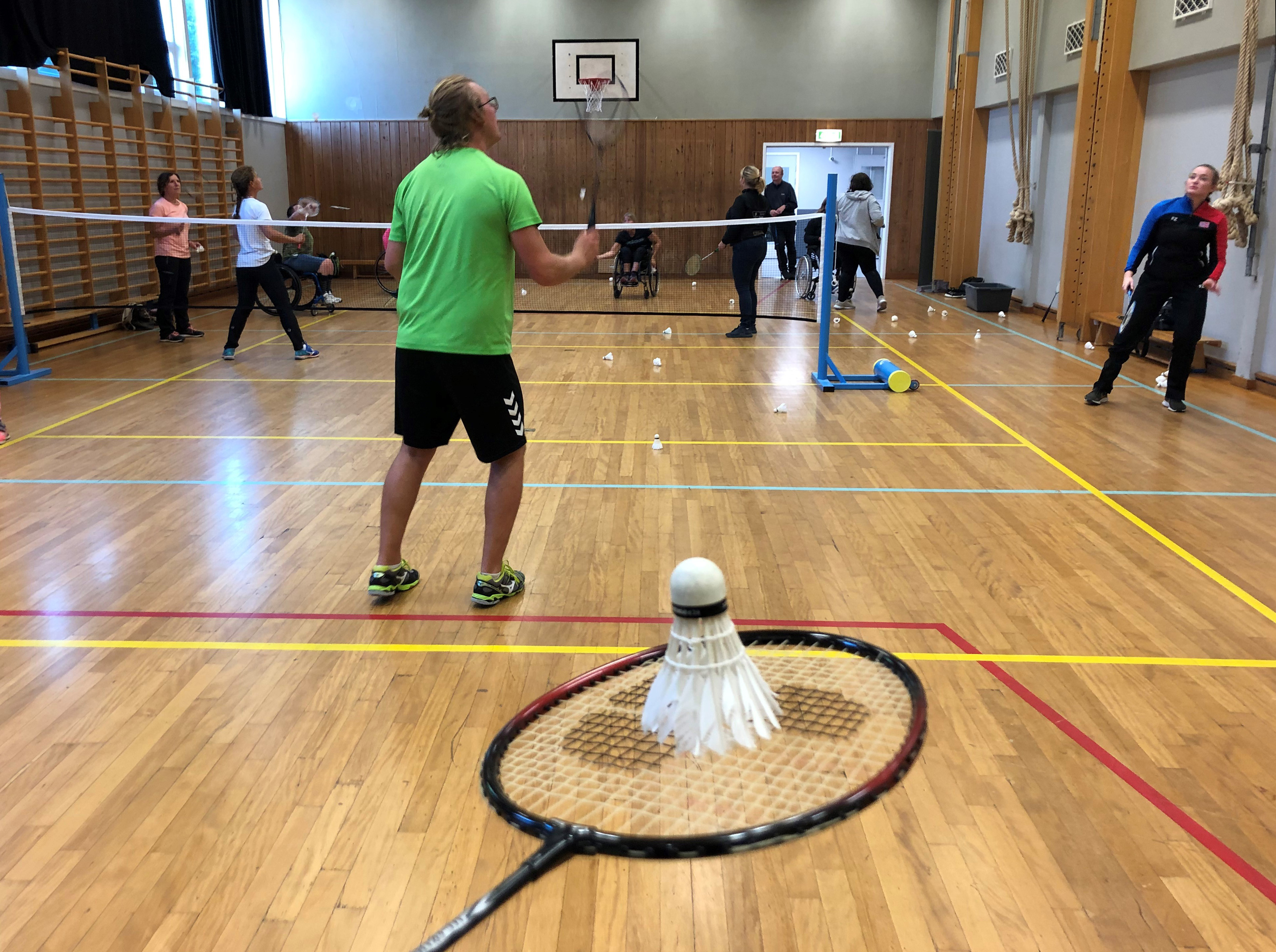 Bildet viser badmintontrening i gymsal for personer med ulike funksjonsnedsettelser