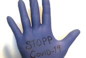 Hånd med teksten Stopp Covid-19