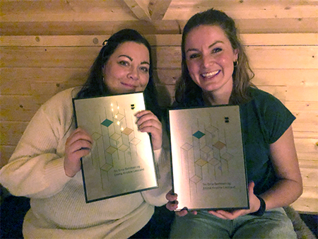 Bilde av Siv Erna Berntsen og Emma Kristine Leesland som holder sine diplomer etter å ha vunnet Frivillighetsprisen 2020
