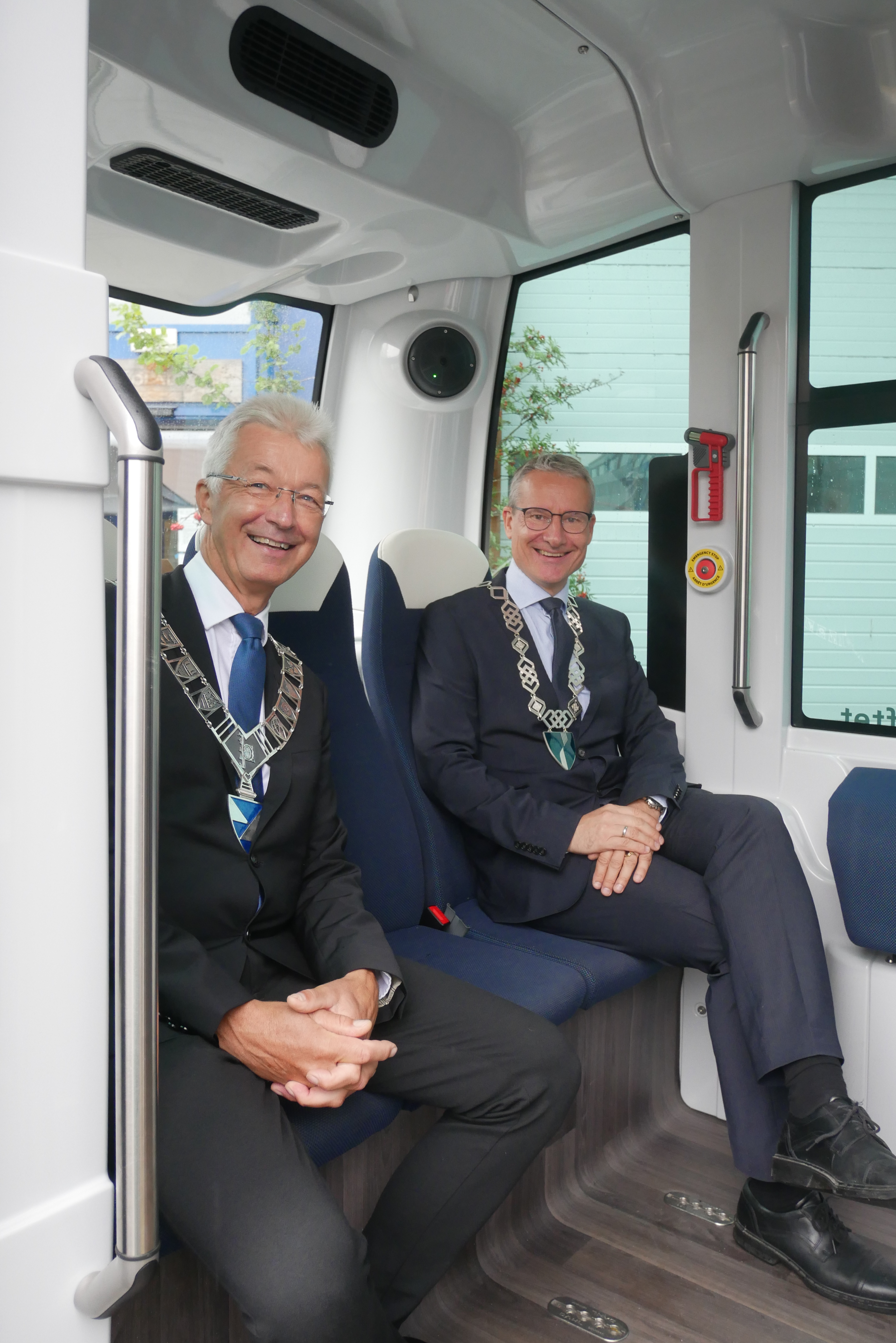 Fylkesordførar Jon Askeland og ordførar i Sunnfjord Olve Grotle om bord i den sjølvkøyrande bussen Olai.