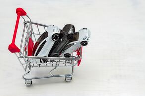 trolley-cart-full-of-toy-cars-tesla-on-a-white-bac-2021-09-04-10-18-03-utc