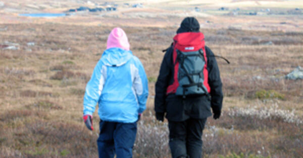 Bilde av to personer som går tur i terrenget