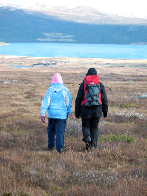 Bilde av to personer som går tur i terrenget. Foto: Anders Midtsundstad