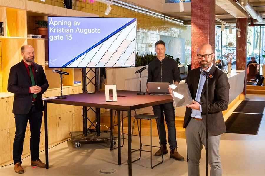 asmus Reinvang byråd for byutvikling i Oslo (til venstre) har overlevert FutureBuilt-plaketten til Per Ola Ulseth fra Entra ASA. I bakkant står Stein Stoknes fra FutureBuilt (Foto: Tove Lauluten)