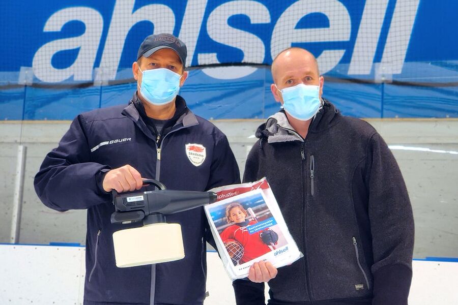 Ahlsell donerer en smittevernspakke til alle landets ishaller, i håp om å holde hallene åpne så lenge som mulig. Her har daglig leder i Skedsmo Ishockeyklubb, John Obstfelder, mottatt en foggermaskin fra Vegar Carlson i Ahlsell Norge.
