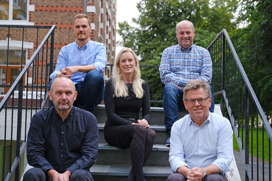 På bildet ser vi: Til venstre bak: Magnus Løining, Koordinator teknisk drift Bygg- og eiendomsavdelingen, Til venstre foran: Steinar Håland, Ingeniør, Bygg- og eiendomsavdelingen, Til høyre bak: Trygve Soland, FDV ingeniør, Bygg- og eiendomsavdelingen, Til høyre foran: Ragnvald Sande, Ingeniør, Bygg- og eiendomsavdelingen, Midten: Nina Mellem, Rådgiver offentlige anskaffelser, Faggruppe innkjøp, Økonomiavdelingen.