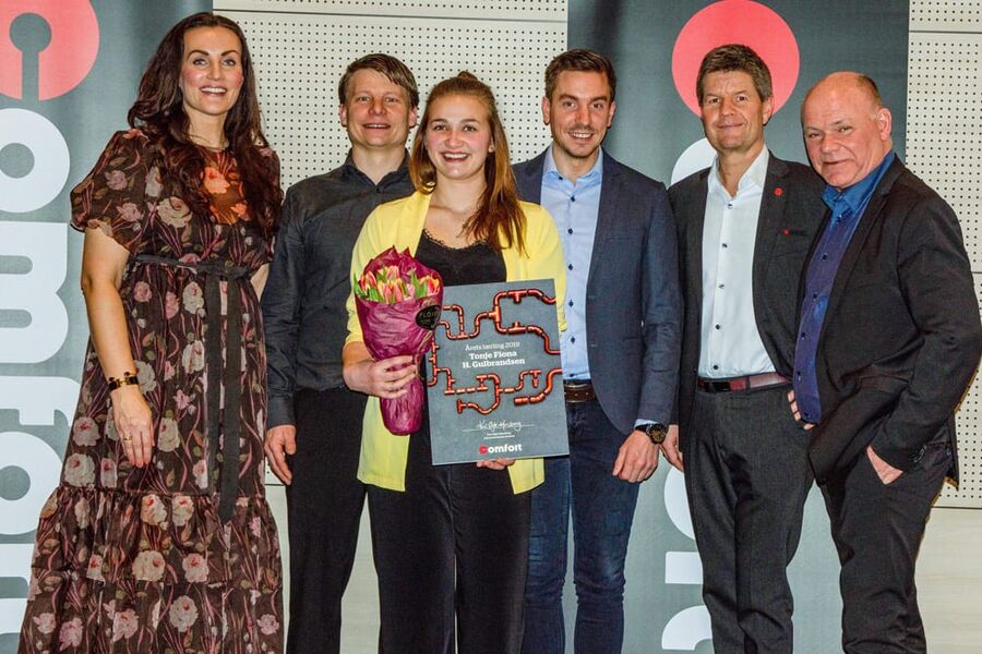 Her ser vi årets lærling i Comfort, Tonje Fiona Gulbrandsen i midten med beviset på utmerkelsen fra kjedekontoret. Rundt henne ser vi fra venstre, Kari Øgle Kjensberg, administrerende direktør i Comfort-Kjeden, Tom Erik Kirkebø, rørleggerformann/BAS, Vegard Øvrebø, prosjektleder i Dale Rør Jarle Amble, teknisk fagsjef i Comfort, og Thorbjørn Theie, administrerende direktør i VVS Norge. 
