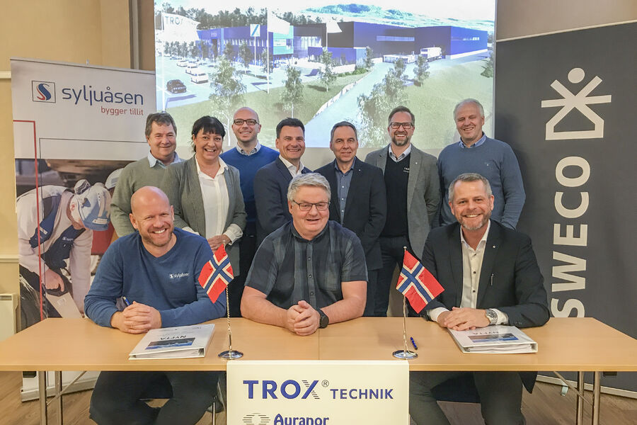  Kontraktspartene flankert av rådgiver fra Sweco og TROX Auranors ledergruppe og prosjektdeltagere. Foran fra v. Anders Myhre og Anders Elje fra Syljuåsen, Peter Sønderskov fra TROX Auranor. Bak fra v. Trond Pettersen, Torunn Lismoen, Tobias Paull, Sturla Ingebrigtsen, Tore Stenbråten, Tormod Grindstad - alle fra TROX Auranor og Per Kristian Borgli fra Sweco. Foto TROX Auranor.