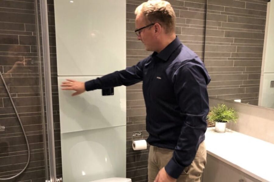 Ronny Holm, daglig leder i Unopax AS, viser baderomskabin med skapet UNOPAX MAXI SPLIT som er koblet til og kjører for fullt. I skapet ser vi varmefordelingen i topp og tappevann i nedre del. Toalett og sisterne ved nedre glass.