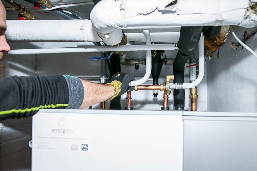 Markus Loostrand i Energico monterer væske-til-vann-varmepumpe.
