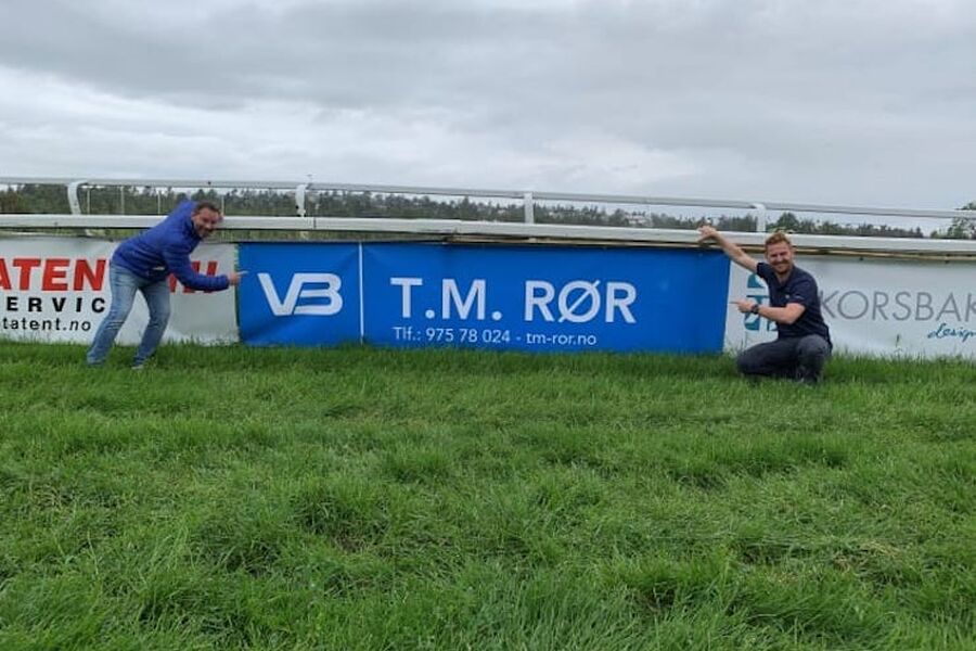 VB T.M. Rør er godt synlige på Øvrevoll Galppbane på Jar. Daglig leder Tor Marius Wilhelmsen viser stolt fram sitt nye VB-banner sammen med Kristoffer Adde, regionsansvarlig i Øst.