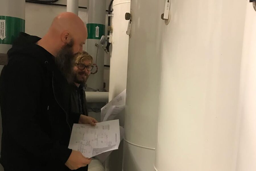 Bjørn Ludvigsen og Harald Taxt Walnum fra SINTEF Byggforsk planlegger montering av måleutstyr i en varmesentral hos Boligbygg. Foto: Boligbygg 