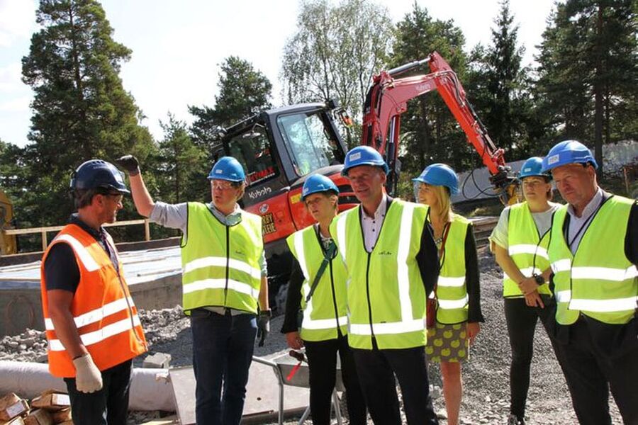 En pekende prosjektleder Flemming Idsøe viser gjerne frem den innovative byggeplassen til byråd Geir Lippestad (i midten). Med på besøket var også Marianne Brath Lien, Bettina Thorvik, Lene Lad Johansen (alle fra byrådsavdlingen for næring og eierskap), samt Omsorgsbyggs adm.dir. Per Morten Johansen.