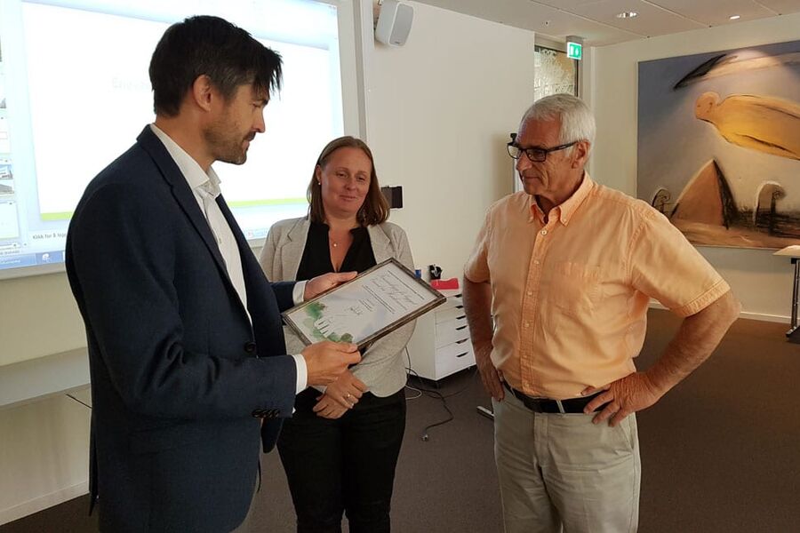 Bjørn-Osvald Skandsen i GK overrekker bekreftelsen på vinkassen til Linda Løtvedt Aas, og Arild Lunde i Forsvarsbygg.


