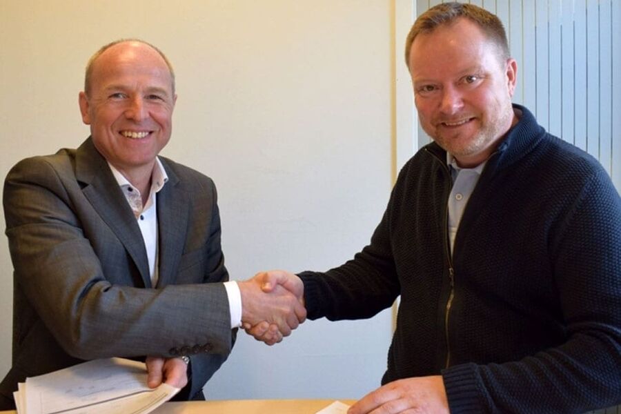 Administrerende direktør Kenneth Johnsen i AFK eiendom FKF (til v.) og daglig leder Jonas Ask i Klima og Bygg tar hverandre i hånda etter signert rehabiliteringskontrakt. (Foto: André Strand, AFK eiendom FKF)