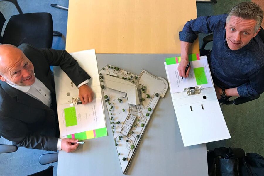 Per Morten Johansen fra Omsorgsbygg og Tor Unneland fra Varden Entreprenør setter sine signaturer på kontrakten for Kilden barnehage.