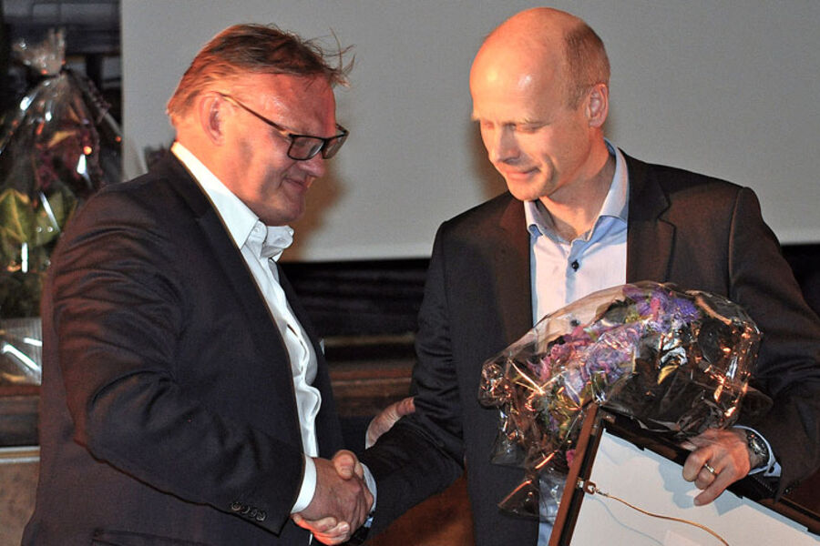 Jon Tveiten (t.v.), adm.dir. i Norsk Energi, overrekker årets EMIL-pris til Øyvind Nilsen i Hafslund Varme AS. Prisen er et bilde som viser dampmaskinhallen i dampsentralen i Rosenkrantzgate i Oslo i 1922 der fjernvarmeutbyggingen i Oslo startet. Bildet er tatt av en ukjent fotograf, og originalen eies av Oslo Bymuseum.  