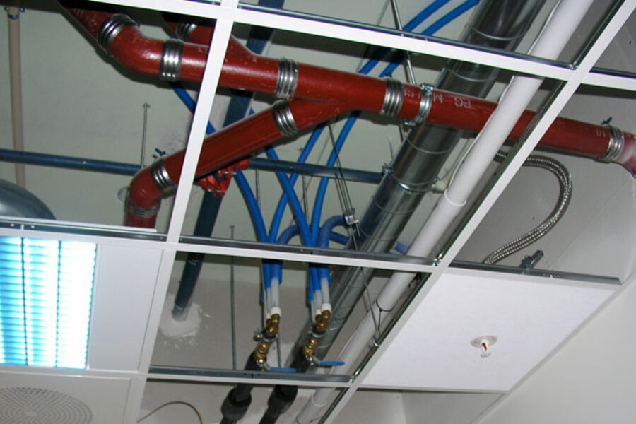Bildet viser tildekket, utskiftbar rørføring over systemhimling i korridor. Foto: SINTEF Byggforsk