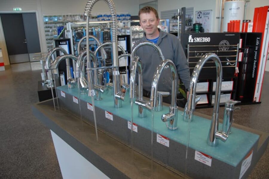 Martin Nygaard viser noen av butikkens kraner med innlagt vann. Foto: Per Henriksen