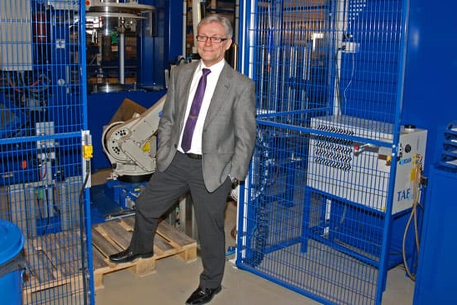 Administrerende direktør Tore Holthe har grunn til å smile. Her fotografert foran et bur med robot.