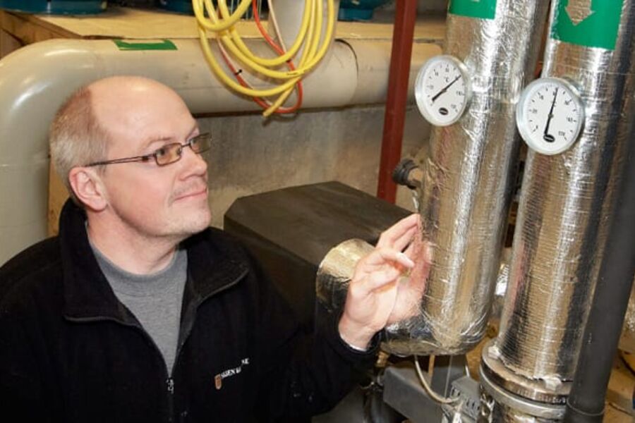 Vaktmester Leif Gregersen i Skien kommune har en enkel jobb i fyrrommet. Her sjekker han temperaturen på vannet som kommer inn i systemet.