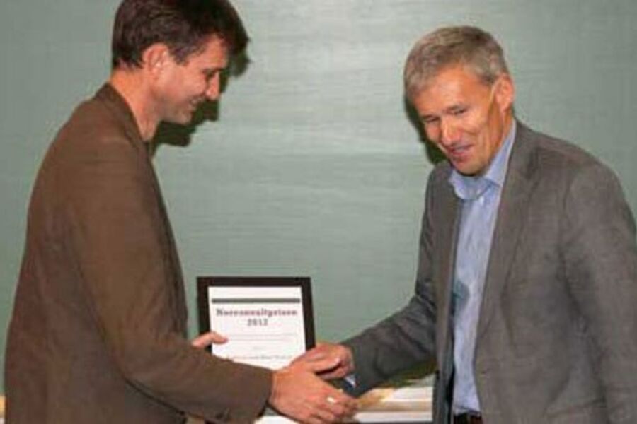 Norconsults adm.direktør John Nyheim gratulerer Arild Clausen med prisen. Foto: Norconsult.