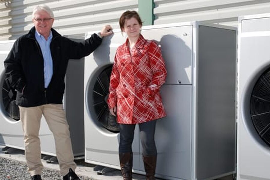 Administrerende direktør Thore Sydtangen og markedssjef Kristin Engely med noen av varmepumpene som leverer varme til akkumulatortankene inne.