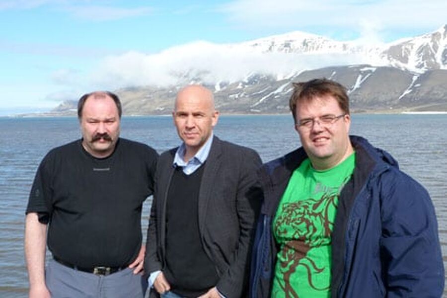 I midtnattsol og med Adventfjorden utenfor Longyearbyen i bakgrunnen gleder man seg over at NVS-oppkjøpet er i orden. Fra venstre: Tidligere eier og daglig leder, Bård Gundersen, administrerende direktør i NVS Torkil Skancke Hansen og bedriftens nye daglige leder, Ryno Hansen.