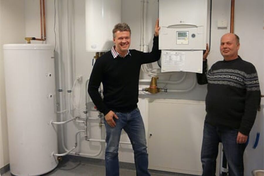 Ronny Kolstad (til venstre)og Salgssjef AWHP (luft/vann)Rune Ågedal (til høyre)Salgstekniker AWHP (luft/vann. Bildet er tatt i teknisk rom for vannbåren varme i Bauer Energis nye bygg i Kristiansand. Anlegget leverer vannbåren gulvvarme til totalt 500 m2 med kontorer, kurslokaler og verksted.