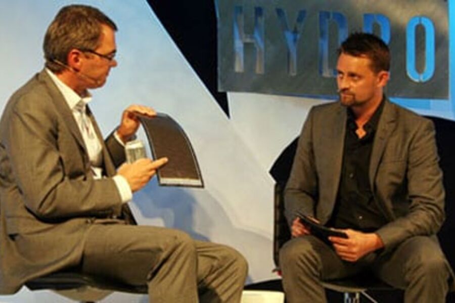 ENERGINØYTRALE BYGG: Hydros konsernsjef Svein Richard Brandtzæg viser fram en fleksibel solenergimodul fra Hydros deleide selskap Ascent Solar i USA. Til høyre debattlederen Thomas Numme. (Alle fotos: Eva S. Mellgren)