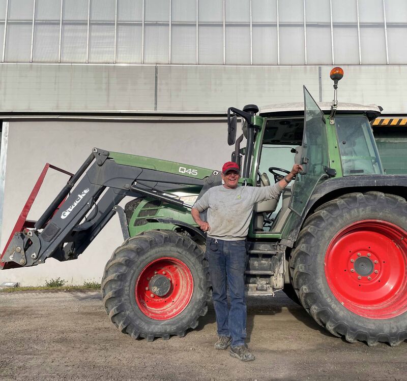 Hans Erik Fuglerud i sitt rette element, ved siden av en traktor på Snarum gård.