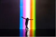 En som danser i regnbue-lyssetting