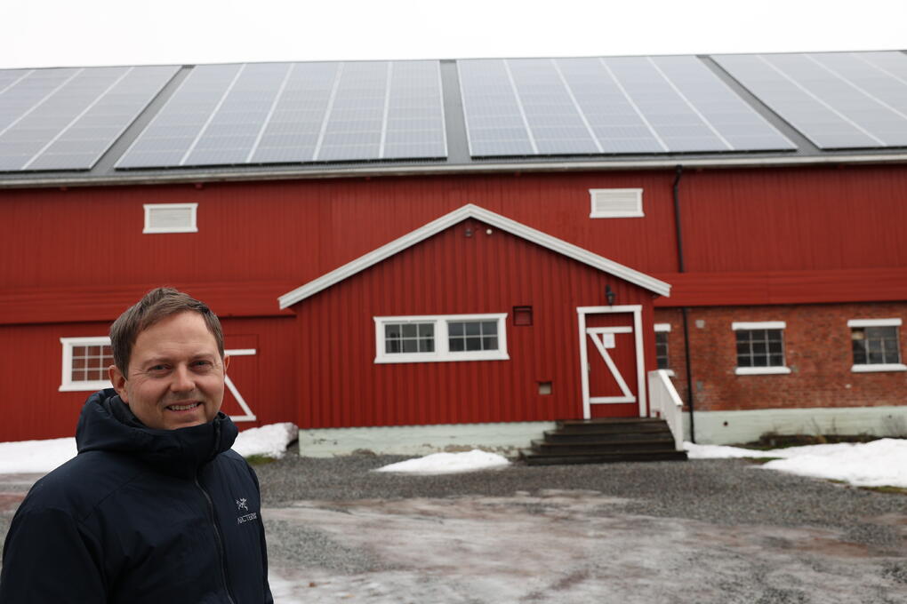 Kyllinghuset: Ole Albert Bøhn foran kyllinghuset med solcellepanelene som forsyner gården med strøm.
