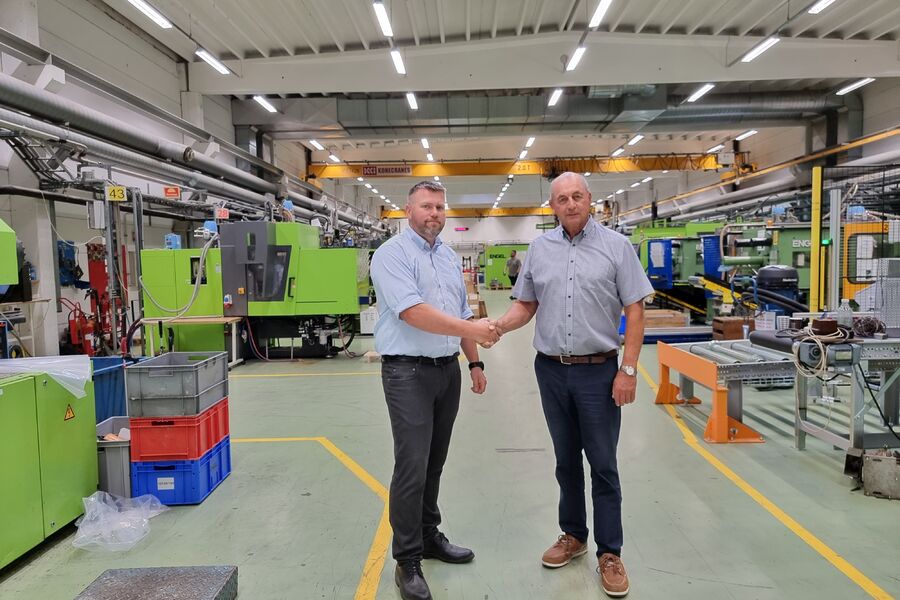 Roy André Magnussen (til venstre), administrerende direktør i OSO Hotwater Group, og Bjørn Lie, daglig leder i OM BE Plast, tar hverandre i hånden etter at de har blitt enige om oppkjøpet.