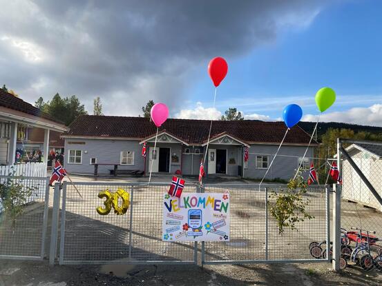 Barnehageporten pyntet med ballonger og plakat.
