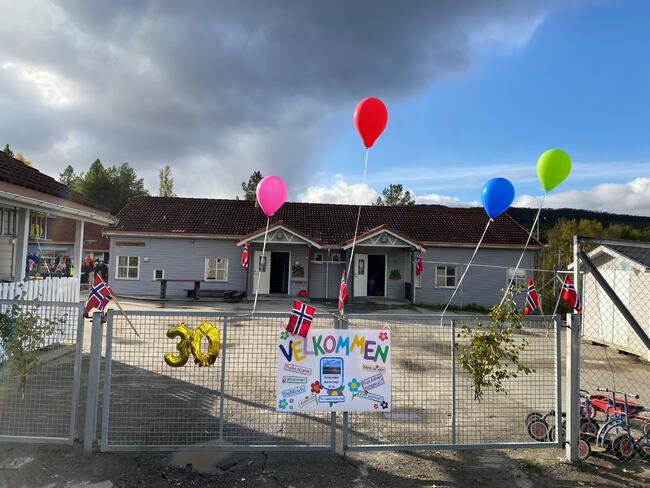 Barnehageporten pyntet med ballonger og plakat.