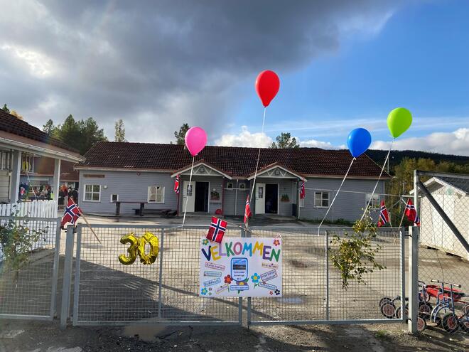 Barnehageporten pyntet med ballonger og plakat.