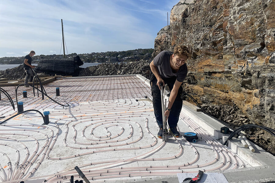 Kunden ønsket en jevn oppvarming i huset og Flekkerøy VVS valgte å gå for 16mm rør for å få en jevn fordeling av varmen som er lagt på isopor i betong. Her jobber rørlegger Per Helge Norheim med legging av rørene.