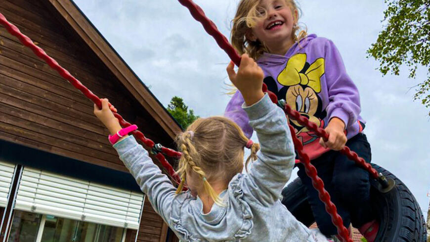 Barnehageopptaket med to jenter som leker ute