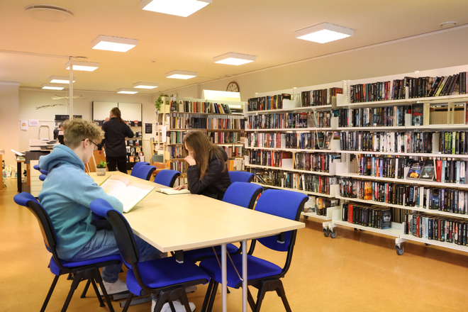 Elever leser på biblioteket