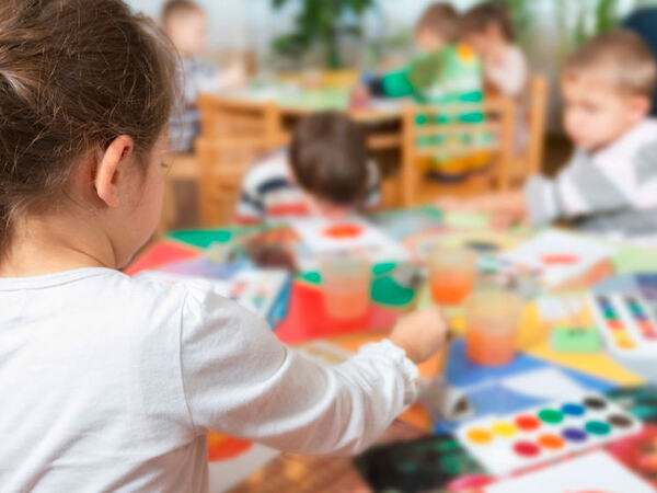 Barn som maler med vannmaling i barnehagen sin