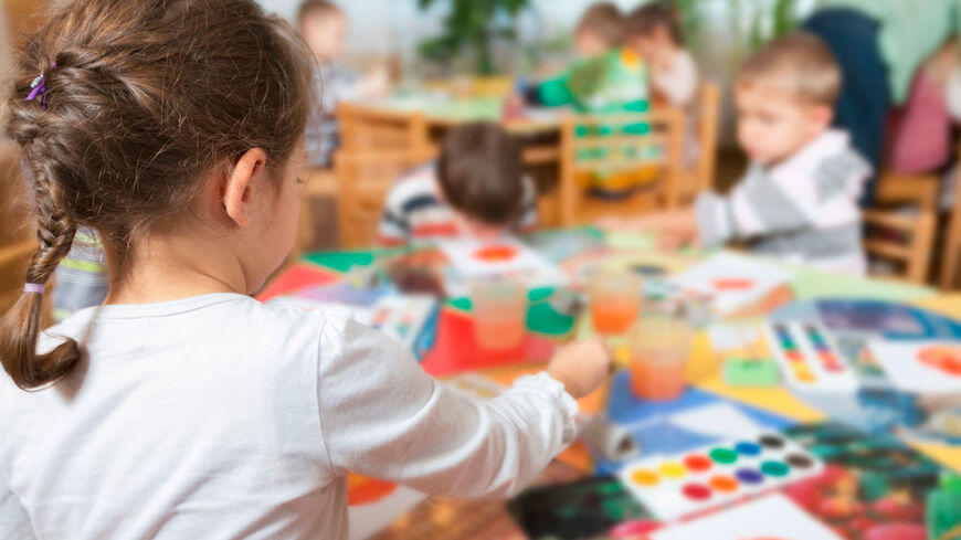 Barn som maler med vannmaling i barnehagen sin