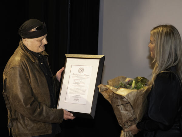 Harald Henden mottar PKs ærespris av leder Cicilie S. Andersen i Pressefotografens Klubb. (Foto: Morten M. Løberg)