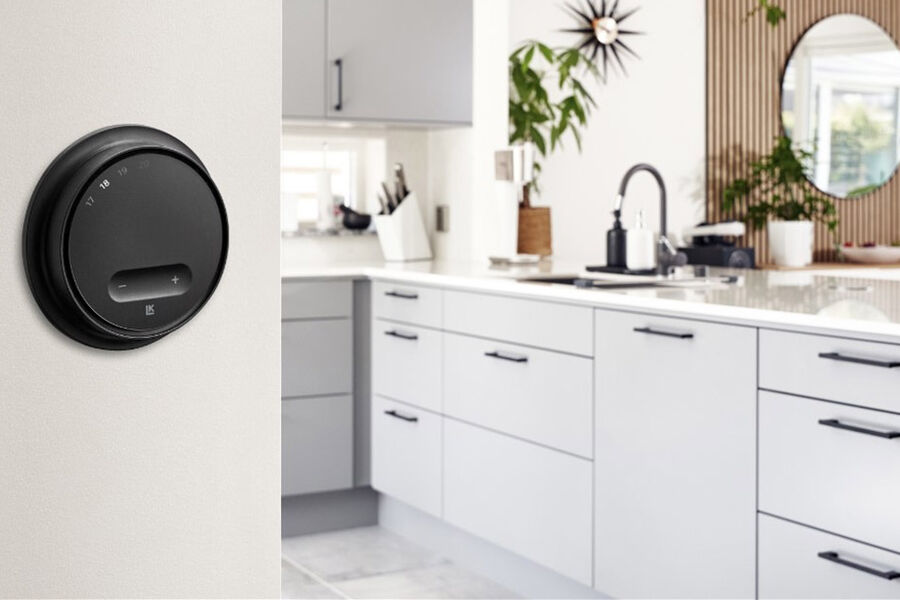 LK Arc termostaten i svart montert på kjøkkenveggen.